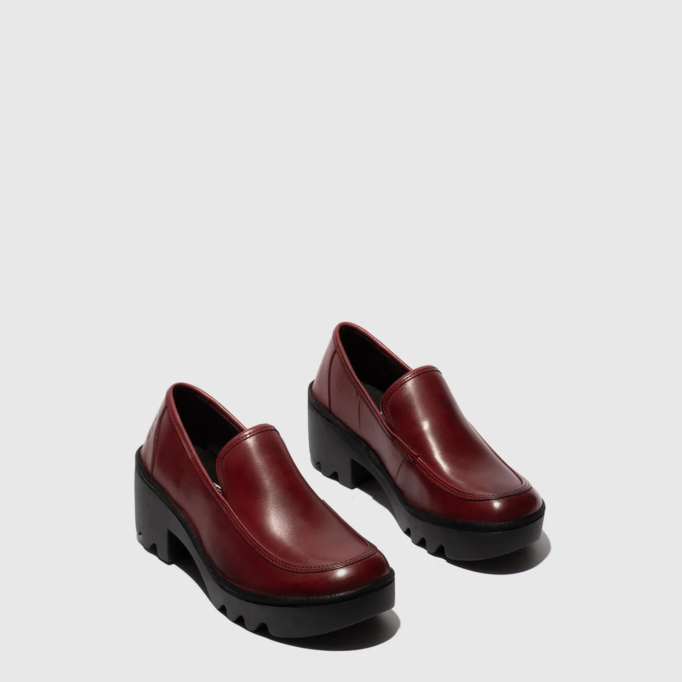 Pair of burgundy leather shoes on a light gray background