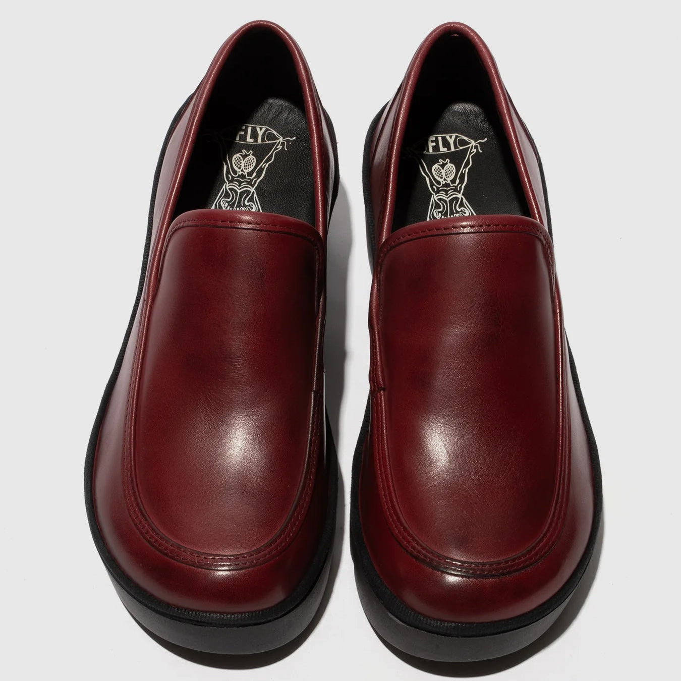 Pair of maroon loafers on a light gray background
