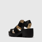 Black sandal with a platform sole on a light gray background