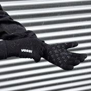 Black gloves with 'vessi' branding on a metallic surface