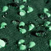 Close-up of green water droplets on a textured surface