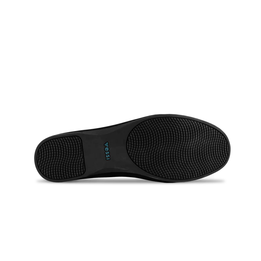 Black shoe sole with Vessi branding on a white background
