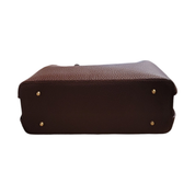 Brown textured handbag with gold studs on a white background