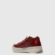 Red sneaker with white sole on a light gray background