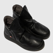 Pair of black leather ankle boots on a light gray background