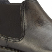 Close-up of a black leather shoe with a white background
