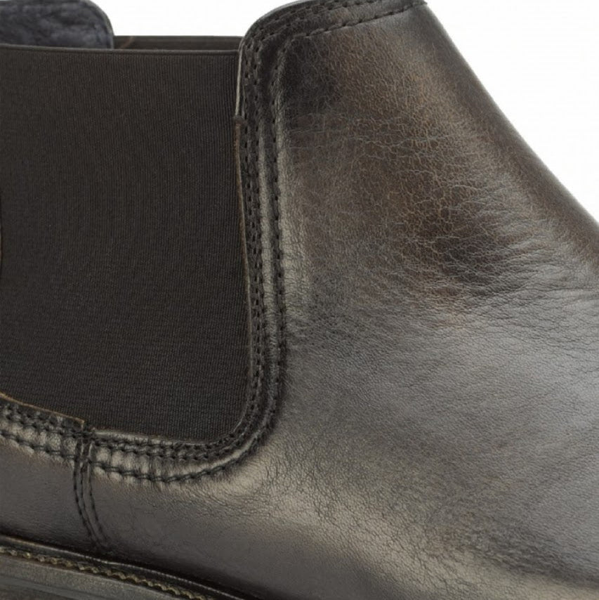 Close-up of a black leather shoe with a white background