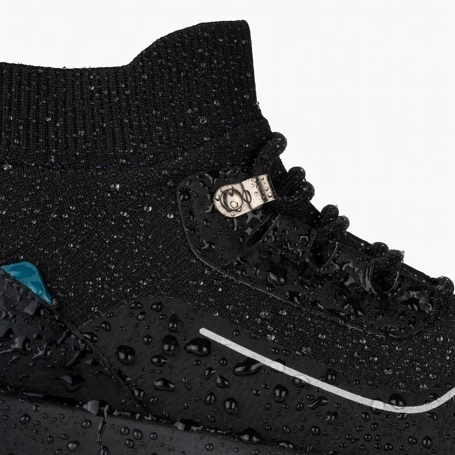 Close-up of a black sneaker with water droplets on a white background