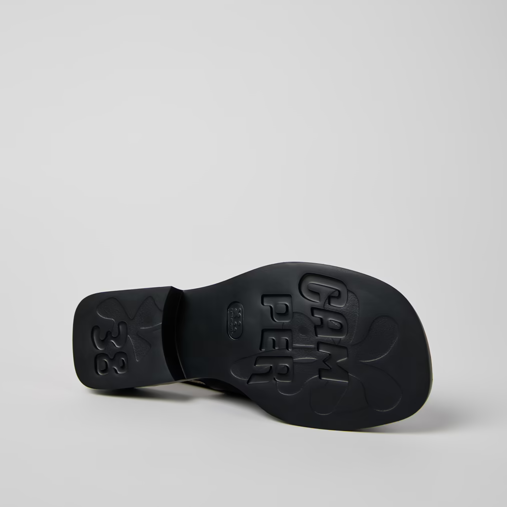 Black sandal sole with brand name on a light gray background