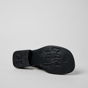 Black sandal sole with brand name on a light gray background