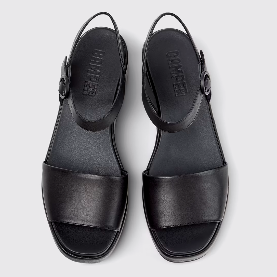 Black sandals with 'Camper' branding on a light gray background