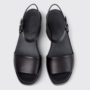 Black sandals with 'Camper' branding on a light gray background