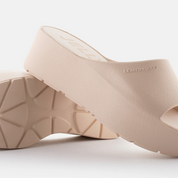 Beige wedge sandals on a light gray background