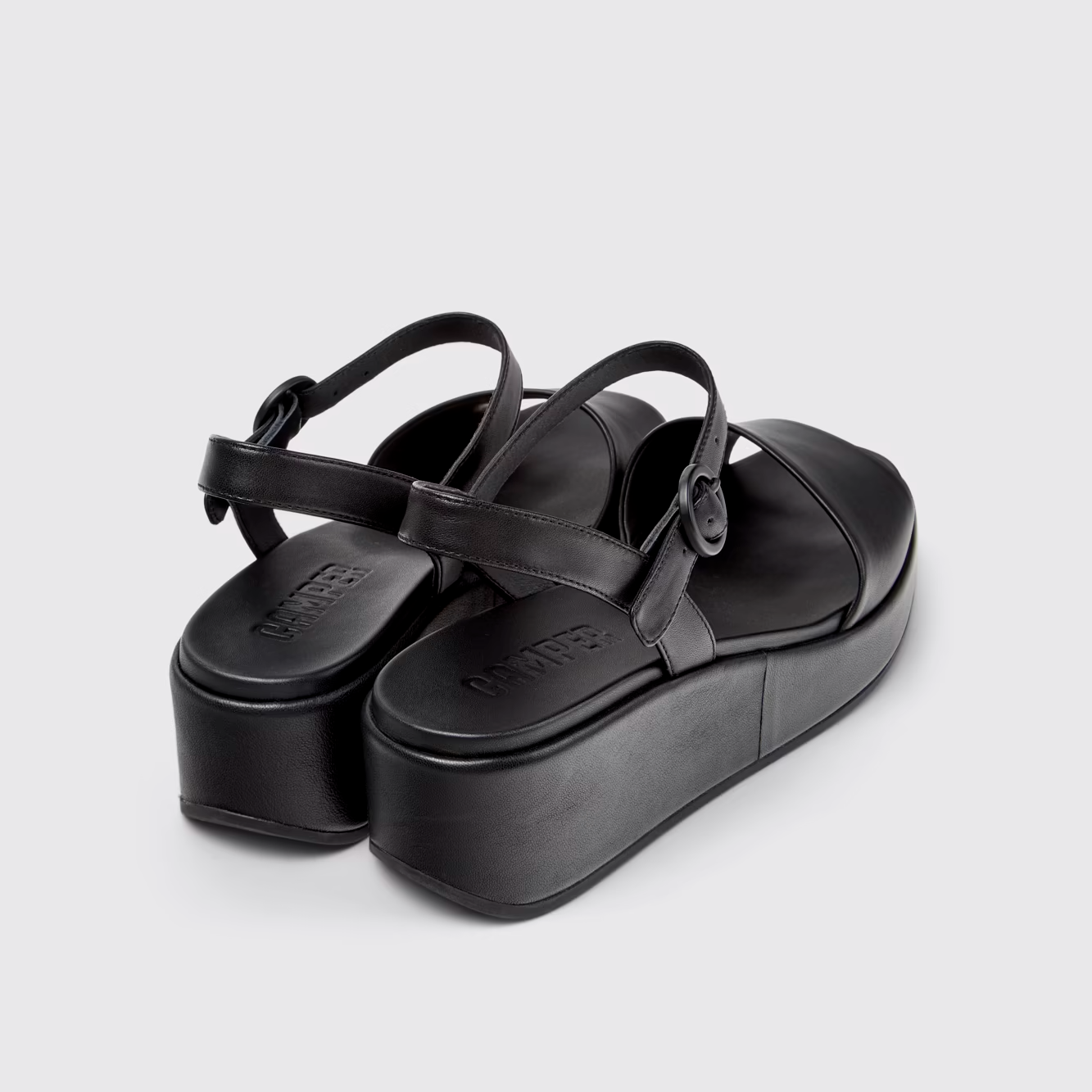 Black platform sandals on a light gray background
