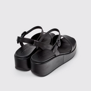 Black platform sandals on a light gray background