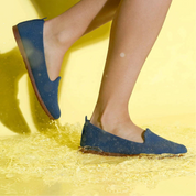 Blue shoes being worn on a yellow background