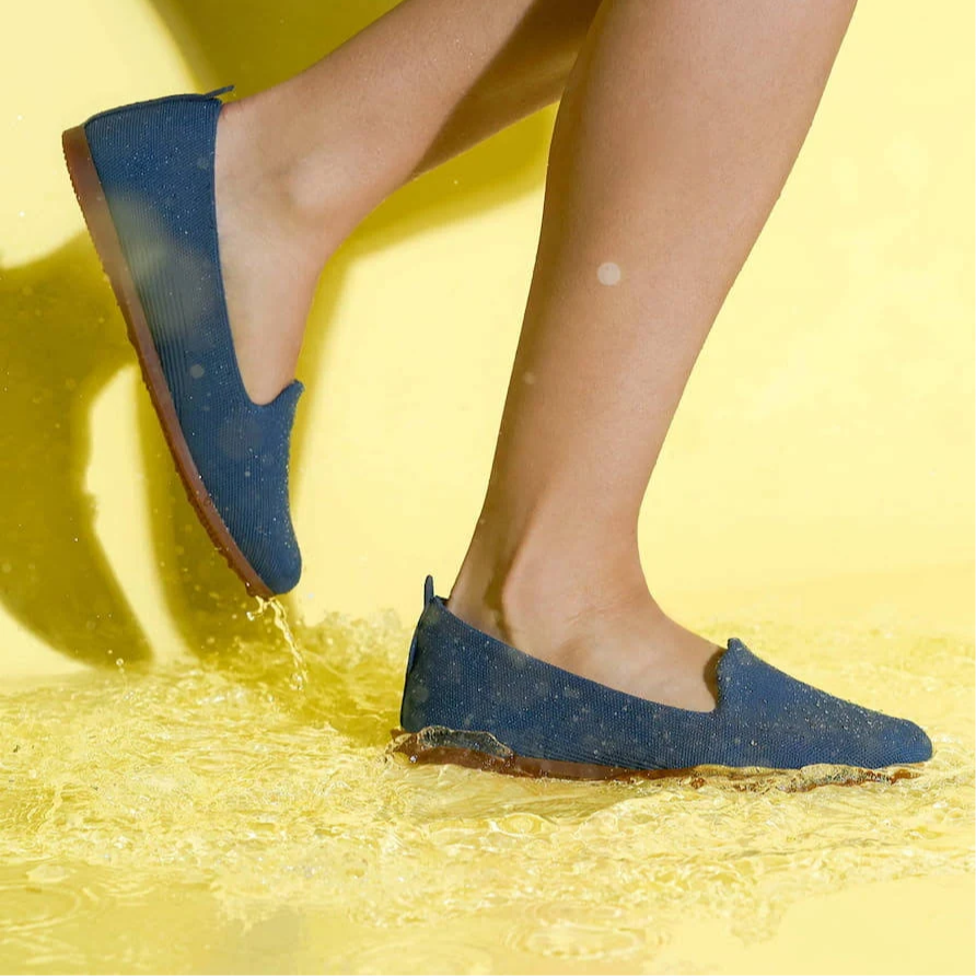 Blue shoes being worn on a yellow background