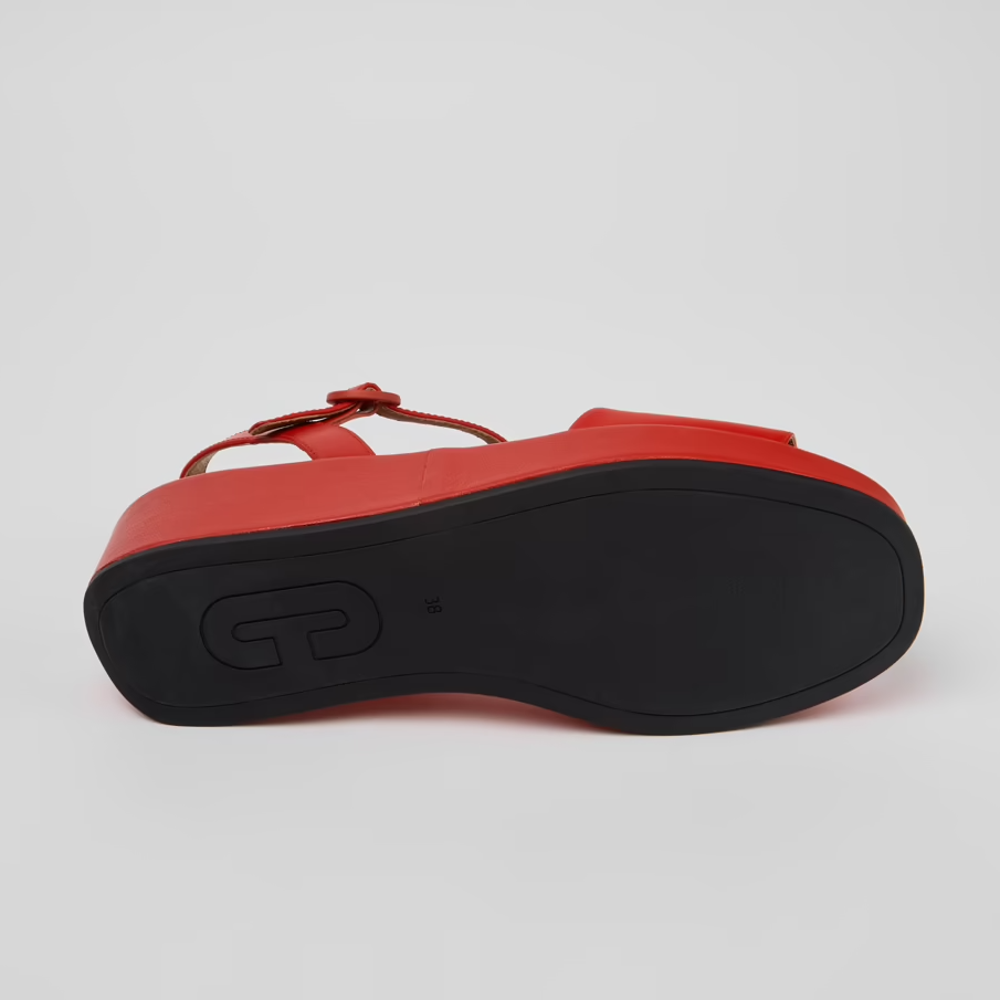 Red sandal with a black sole on a light gray background