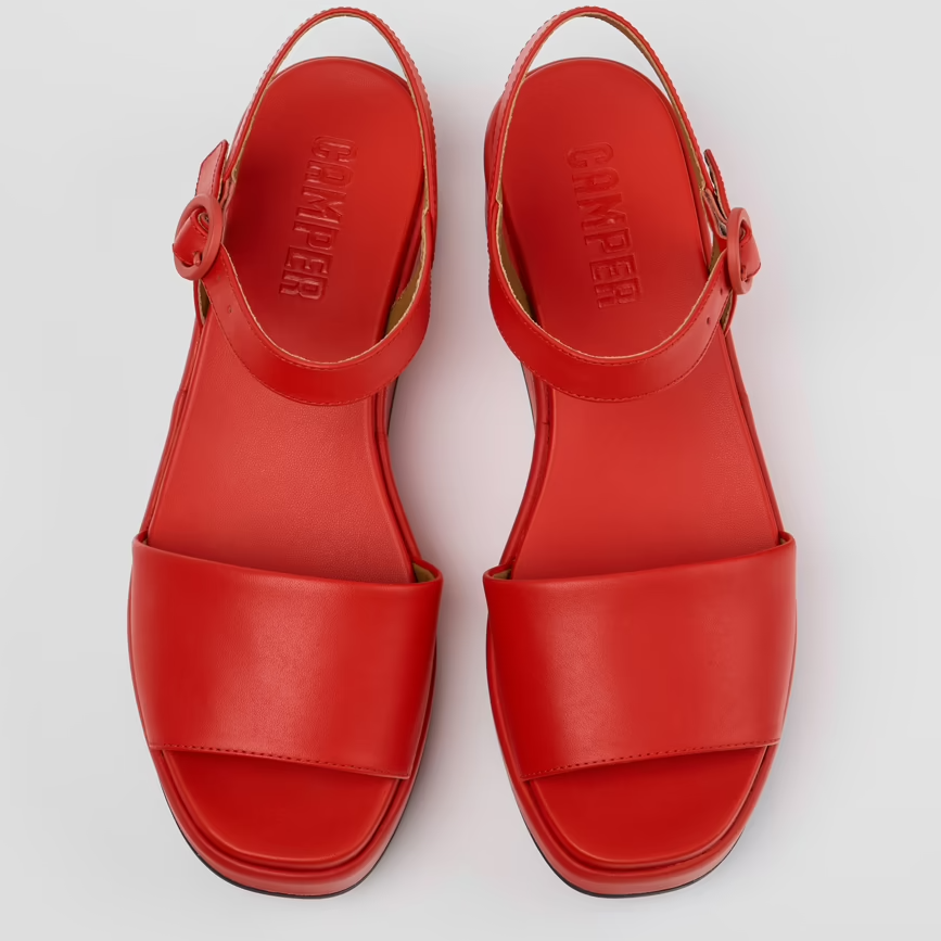 Red sandals with a brand logo on a light gray background