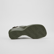 Green sandal with brand name on sole against a white background