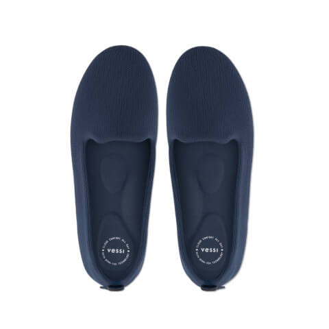Pair of navy blue slippers with 'Vessi' branding on a white background